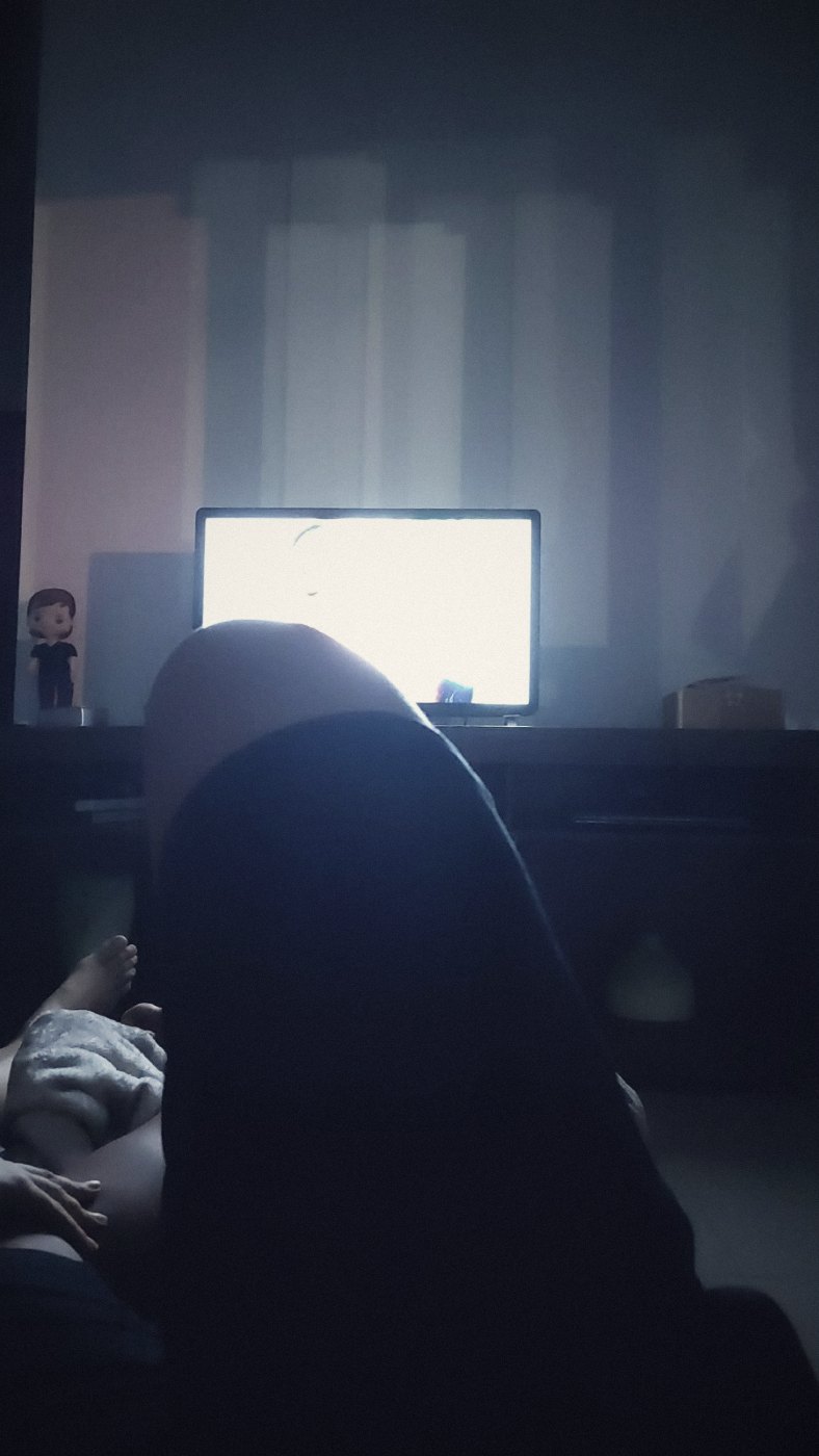 Nós dois no sofá, no escuro, com a TV ligada, naquela noite
